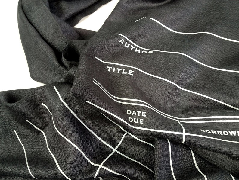 May include: Black fabric scarf with white lines and the words "AUTHOR", "TITLE", "DATE DUE", and "BORROWER" printed on it.