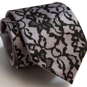 May include: A gray silk tie with a black lace pattern.