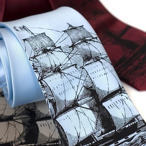 Può includere: Due cravatte di seta con un'illustrazione di una nave in bianco e nero. Una cravatta è blu chiaro e l'altra è bordeaux scuro.
