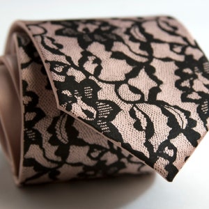 May include: A pink tie with a black lace pattern.
