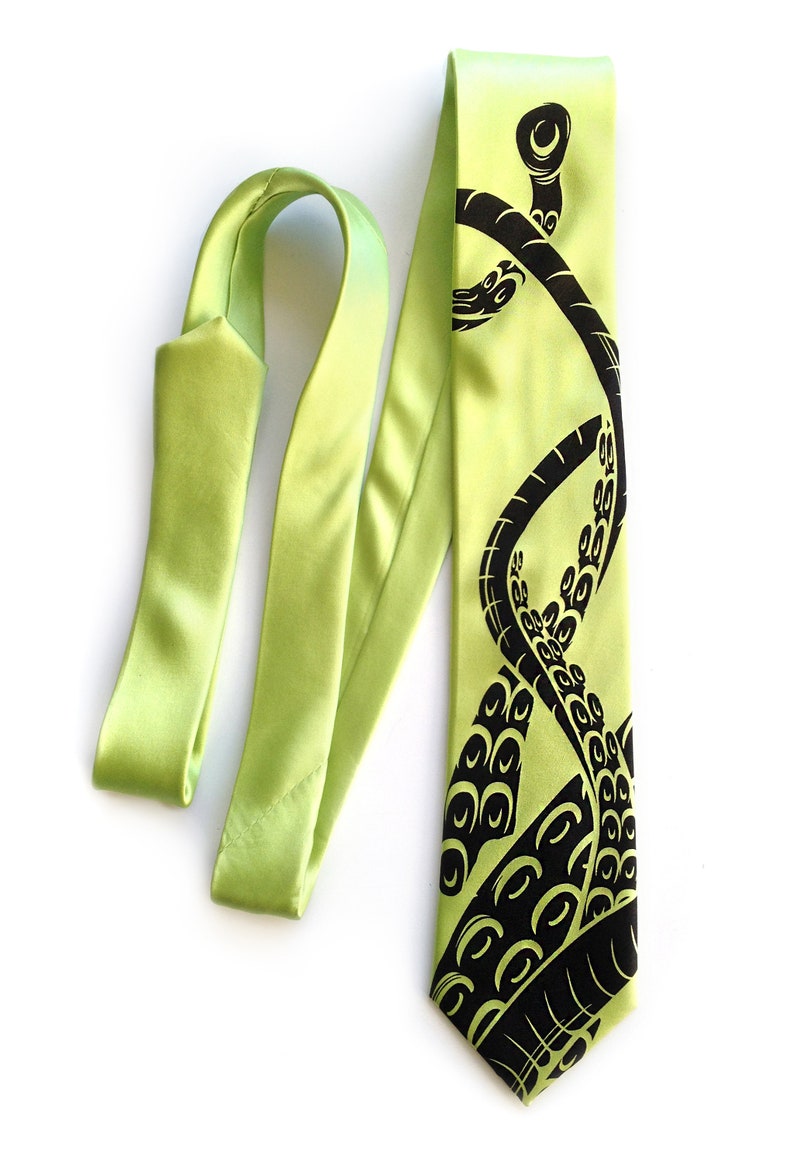 Puede incluir: Una corbata de seda verde lima con un dise&ntilde;o de pulpo negro. El pulpo se representa con tent&aacute;culos que se envuelven alrededor de la corbata.