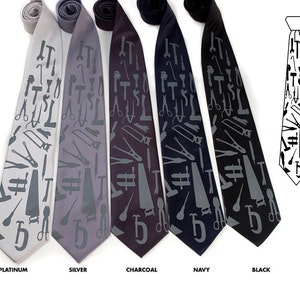 May include: Five silk ties with a repeating pattern of tools in gray on different colored backgrounds: platinum, silver, charcoal, navy, and black.