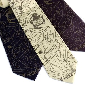 May include: Three silk neckties with a map pattern. The ties are in shades of brown and black. The map pattern includes lines and numbers. The text on the ties reads "Aviation 200 Streamline".