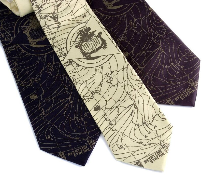 May include: Three silk neckties with a map pattern. The ties are in shades of brown and black. The map pattern includes lines and numbers. The text on the ties reads "Aviation 200 Streamline".