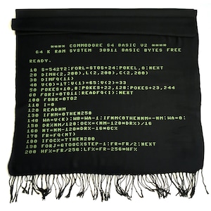 May include: A black and green scarf featuring a vintage Commodore 64 computer code design. The code is written in green text on a black background. The code includes the text "COMMODORE 64 BASIC U2" and "READY."