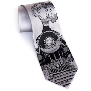 May include: A silver silk tie featuring a black and white illustration of a vintage steam locomotive with the number 1873 on the front.