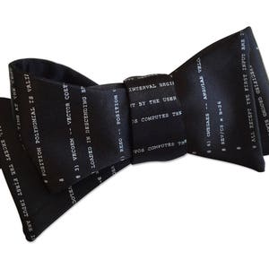 May include: Black bow tie with white text printed on it. The text includes "POSITION POLYNOMIAL IS VALID", "VECTOR COEF", "LOADED IN DESCENDING", "ANGULAR VELO", "REV/CS x D+26", and "ALL EXCEPT THE FIRST INPUT ARE INVALID".