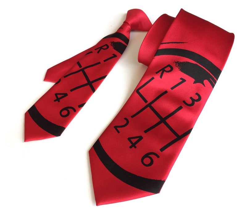 May include: Red silk tie with a black printed gear shift pattern. The pattern includes the numbers 1, 2, 3, 4, 5, and 6.