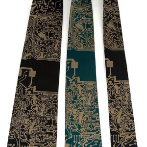 May include: Three neckties with a circuit board pattern. The neckties are in three different widths: standard, narrow, and skinny. The standard necktie is black with a gold circuit board pattern, the narrow necktie is teal with a gold circuit board pattern, and the skinny necktie is black with a gold circuit board pattern.