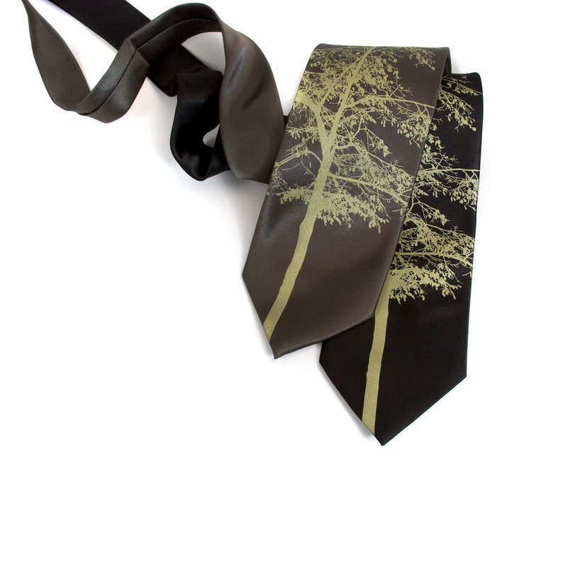May include: Two silk neckties with a gold tree design on a dark brown and black background.