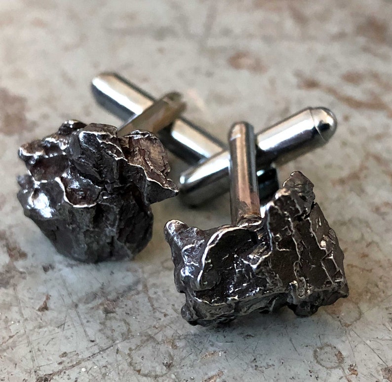 Handmade authentic irony meteorite cufflinks with silver hardware on a beige surface, by Detroit's Cyberoptix Tie Lab.