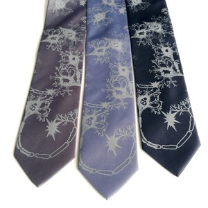 May include: Three silk ties with a gray and white pattern of a neuron. The ties are in shades of gray, blue, and navy.