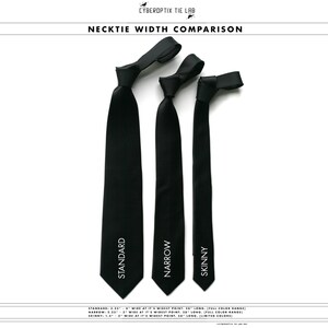 May include: Three black neckties of different widths: standard, narrow, and skinny. The standard tie is 3.25 inches wide at its widest point, the narrow tie is 2.25 inches wide, and the skinny tie is 1.5 inches wide. All ties are 58 inches long.