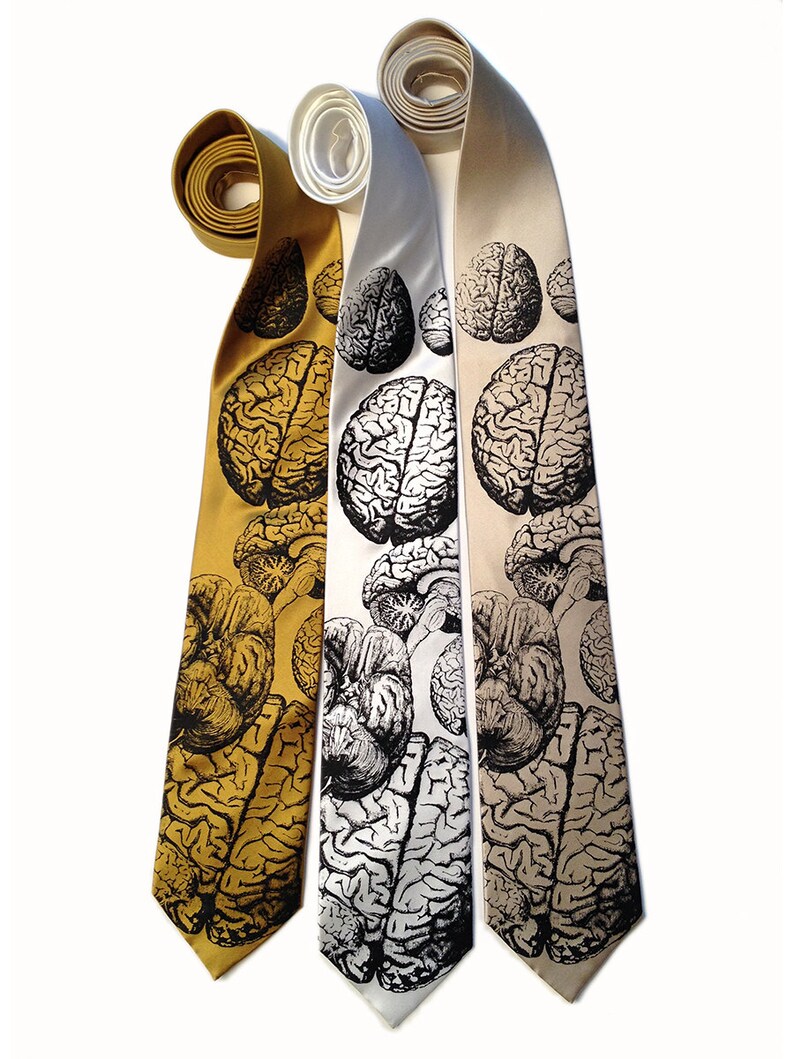 May include: Three silk neckties with a black and white brain print. The ties are in gold, white, and beige.