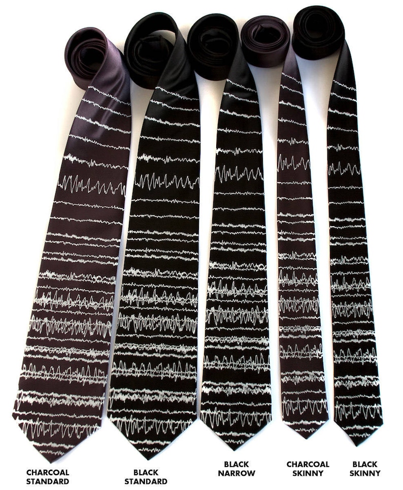 May include: Five neckties with a white EKG pattern on a black or charcoal background. The ties are in different widths, from standard to skinny.