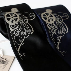 May include: Two silk neckties with a silver gear and floral design. One tie is black and the other is navy blue.