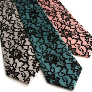 May include: Three silk neckties with a black lace pattern on a white, teal, and pink background.
