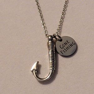 May include: Silver necklace with a fishing hook charm and a round tag that says "Gone Fishing".