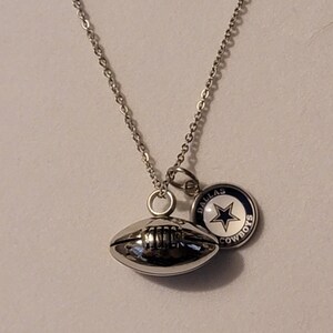 Pu&ograve; includere: Collana con catena d'argento con un ciondolo a forma di pallone da calcio d'argento e un ciondolo d'argento con una stella blu e le parole "Dallas Cowboys".