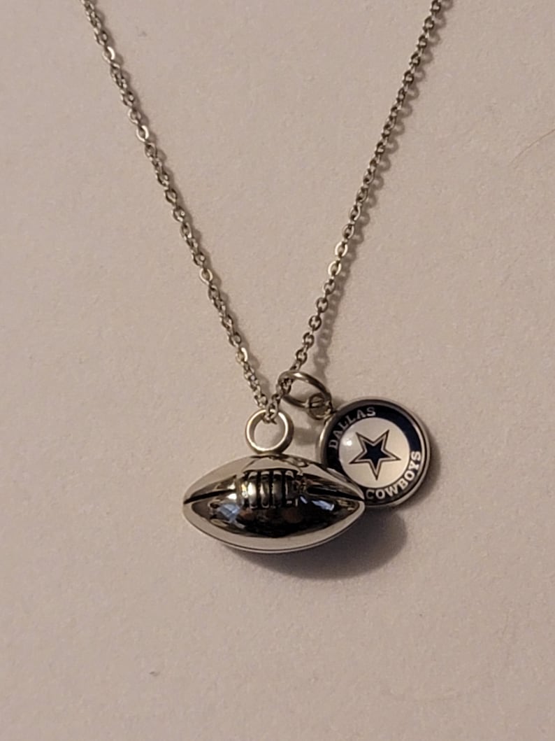 Pu&ograve; includere: Collana con catena d'argento con un ciondolo a forma di pallone da calcio d'argento e un ciondolo d'argento con una stella blu e le parole "Dallas Cowboys".