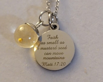 May include: A silver necklace with a round pendant that says "Faith as small as a mustard seed can move mountains Matt. 17:20". The necklace also has a small clear glass bead with a yellow speck inside.