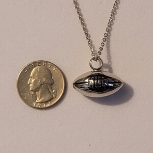 Pu&ograve; includere: Una collana con catena d'argento con un ciondolo a forma di pallone da calcio in argento. Il ciondolo &egrave; circa delle dimensioni di una moneta da 25 centesimi.