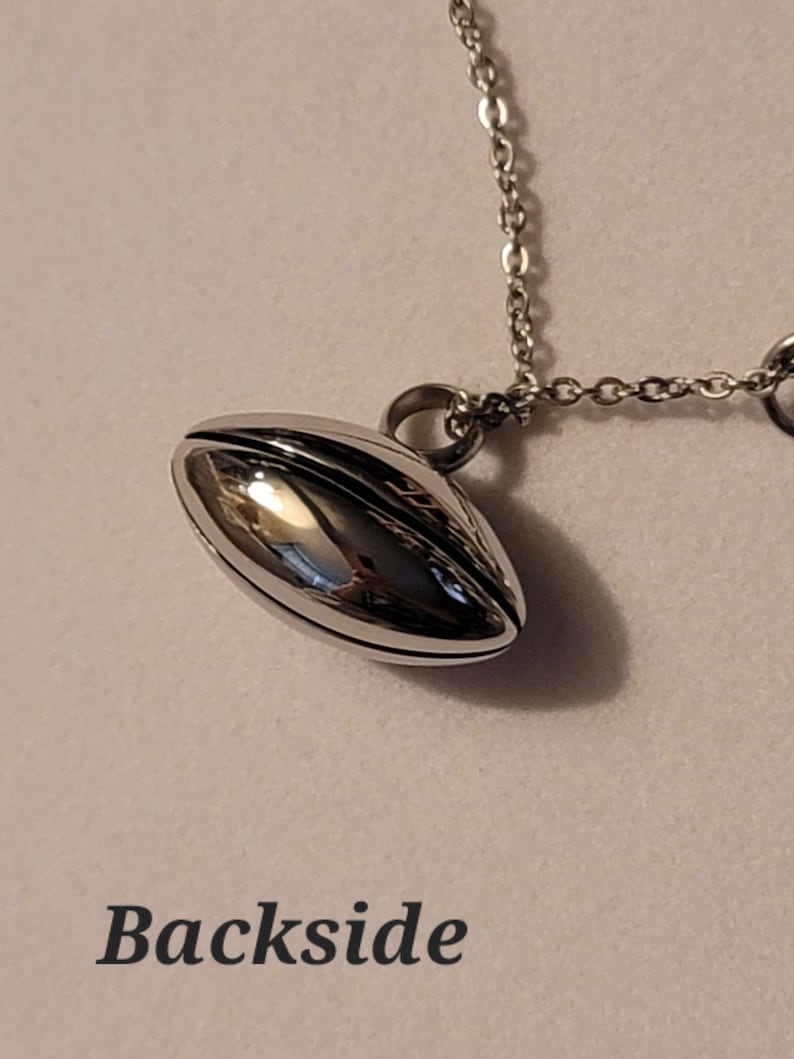 Pu&ograve; includere: Una collana con catena d'argento con un ciondolo d'argento a forma di pallone da calcio. Il ciondolo &egrave; liscio e lucido.