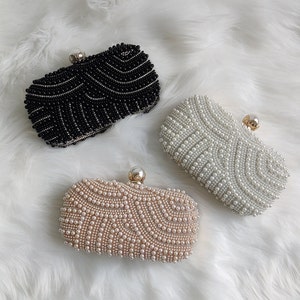 black, cream and rose gold pearl clutch bags on faux fur rug