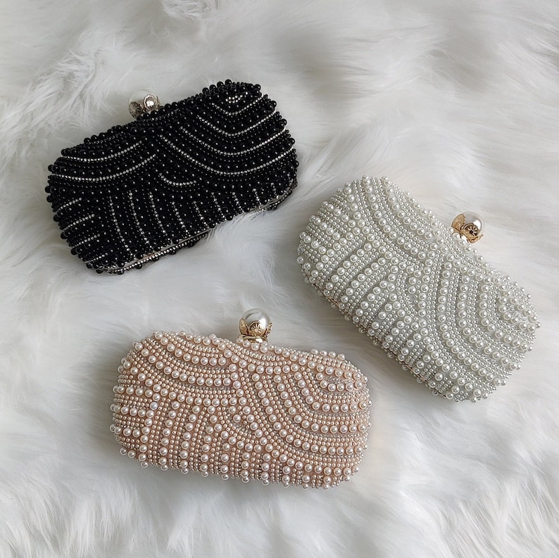 black, cream and rose gold pearl clutch bags on faux fur rug