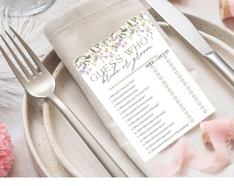 May include: A floral-themed wedding game card with the text "Guess Who? Bride or Groom" and a list of 15 questions to determine who is more likely to do certain things. The card has a floral design with pink, purple, and green flowers.