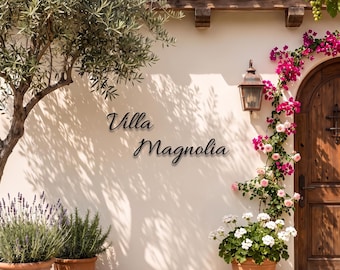 May include: A beige wall features black metal lettering that reads Villa Magnolia. To the left, an olive tree stands near two terracotta pots with lavender and rosemary. To the right, a wooden arched door is framed by pink bougainvillea.