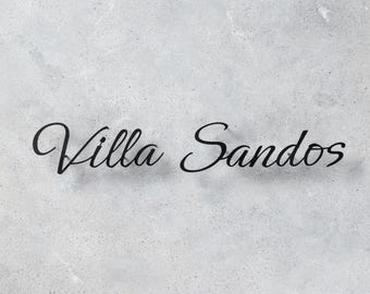 Pode incluir: As palavras "Villa Sandos" são exibidas em uma elegante escrita preta cursiva sobre um fundo texturizado cinza claro. A escrita tem uma leve sombra, adicionando profundidade ao design. A estética geral é simples e sofisticada.