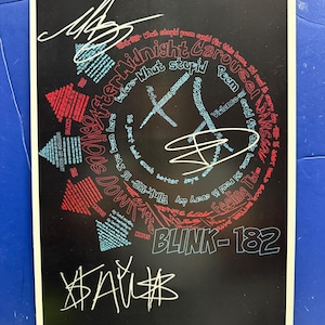 May include: Black poster featuring a stylized design with the band name BLINK-182. The design includes a smiley face with text and signatures in white, red, and blue. The poster has a black background.