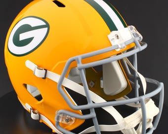 May include: A yellow football helmet with a green and white stripe down the center. The helmet features a gray facemask, white chin strap, and the letter "G" in green on the side. The helmet is a vibrant, glossy color.