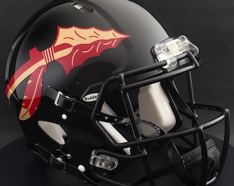 May include: Black football helmet with a black facemask. The helmet features a spear design in maroon and gold on the side. The word "NOLES" is visible on the visor clip. The helmet is a Riddell brand.