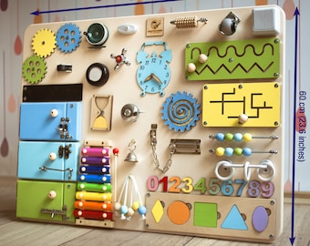 May include: A wooden activity board for toddlers with various textures and activities, including a clock, gears, a xylophone, a maze, a bead roller, and a number puzzle. The board measures 31.4 inches wide and 23.6 inches tall.
