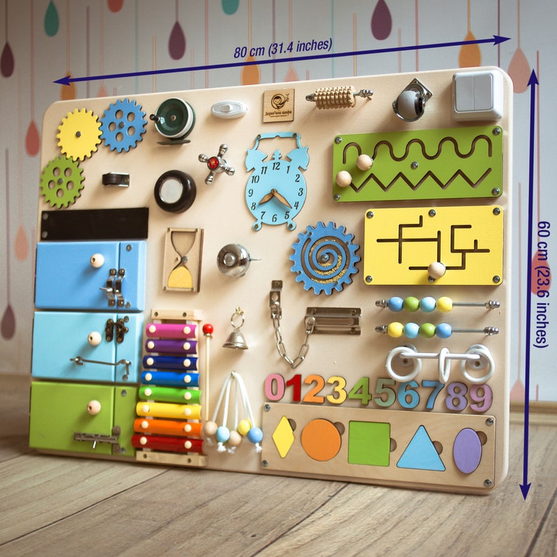 May include: A wooden activity board for toddlers with various textures and activities, including a clock, gears, a xylophone, a maze, a bead roller, and a number puzzle. The board measures 31.4 inches wide and 23.6 inches tall.
