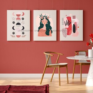 May include: Three abstract art prints with a pink, red, and black color scheme. The prints feature a woman with a floral crown, geometric shapes, and a crescent moon design.