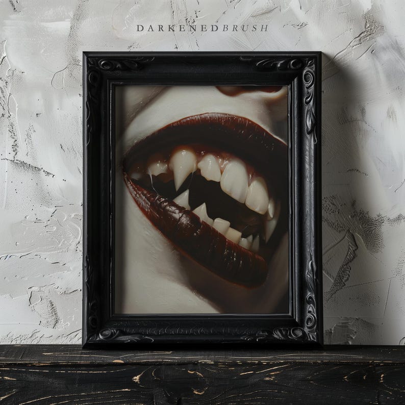 May include: A black framed picture with a close-up of a person's mouth with fangs and dark red lipstick.