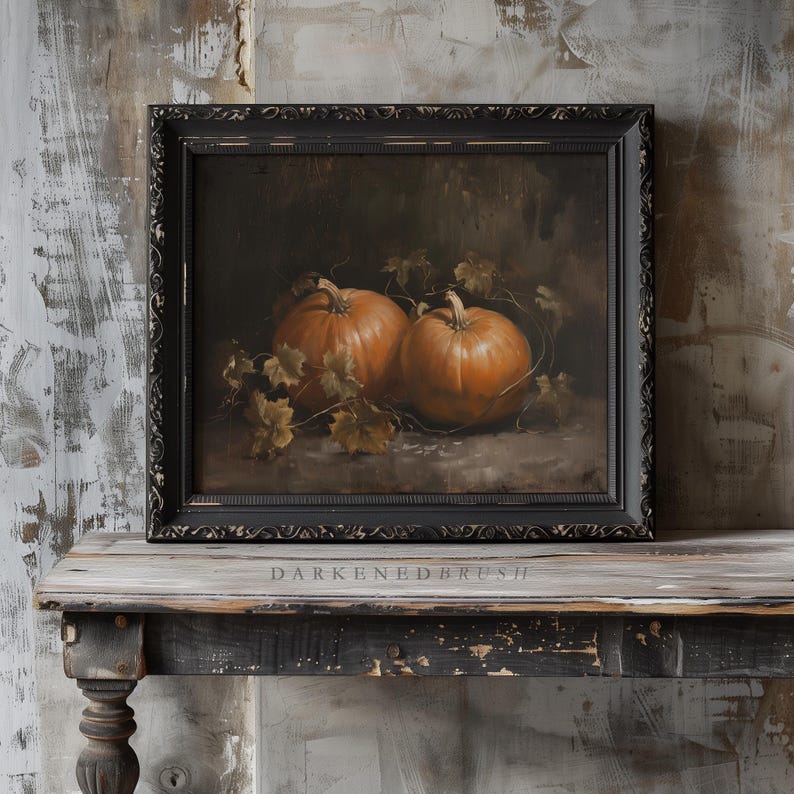 May include: A framed painting of two orange pumpkins with green leaves on a dark background. The frame is black with a decorative border.