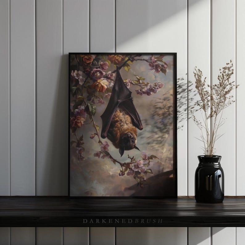 May include: A framed print depicting a brown bat hanging upside down from a branch of a flowering tree. The bat is surrounded by pink and white blossoms. The background is a soft, muted blue.