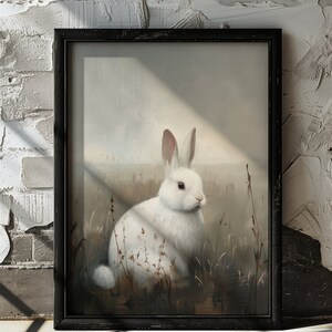 May include: A white rabbit sits in a field of tall grass. The rabbit is facing to the right and has pink ears. The background is a soft, muted brown and white.
