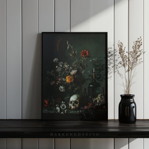 May include: A framed still life print depicting a skull, flowers, and bottles against a dark green backdrop. The flowers are in shades of red, yellow, and white. The skull is white and rests on a table with the bottles.
