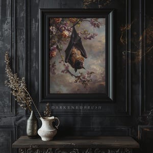 May include: A framed painting depicting a brown bat hanging upside down from a branch of a flowering tree. The bat is a dark brown and black colour with a light brown face. The tree has pink blossoms and green leaves. The painting is set against a dark background with the text "DARKENEDBRUSH" below the frame.
