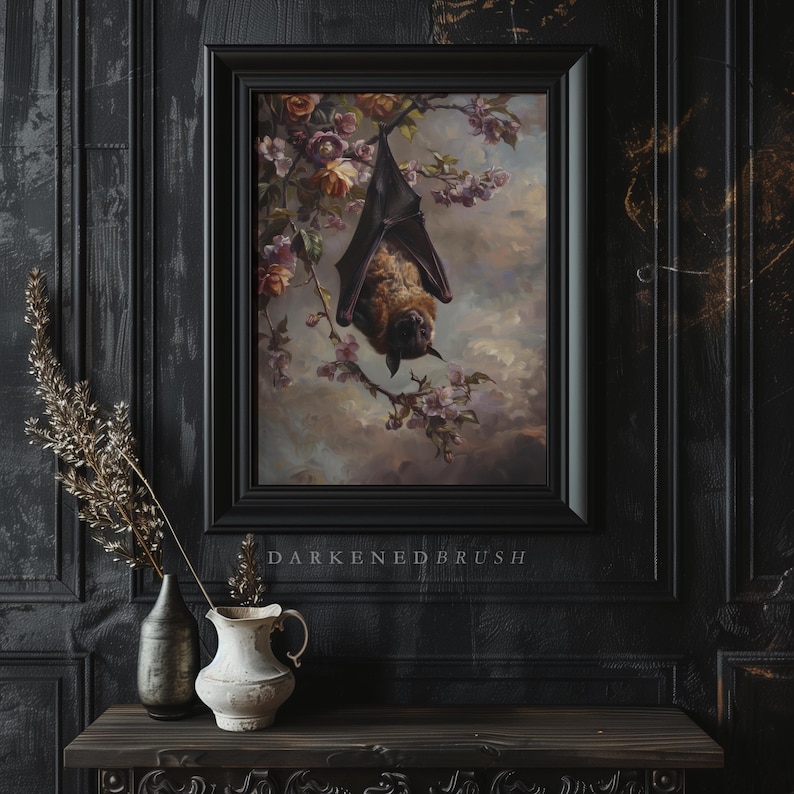 May include: A framed painting depicting a brown bat hanging upside down from a branch of a flowering tree. The bat is a dark brown and black colour with a light brown face. The tree has pink blossoms and green leaves. The painting is set against a dark background with the text "DARKENEDBRUSH" below the frame.