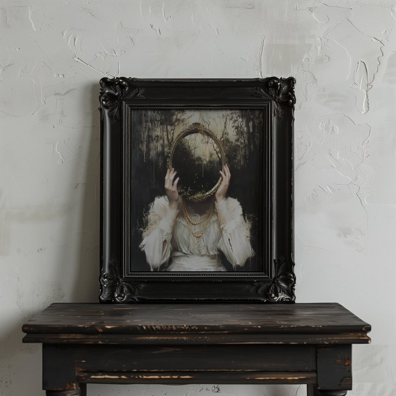 May include: A black framed painting of a woman with a round mirror covering her face. The mirror reflects a dark forest scene. The woman is wearing a white dress and a pearl necklace.