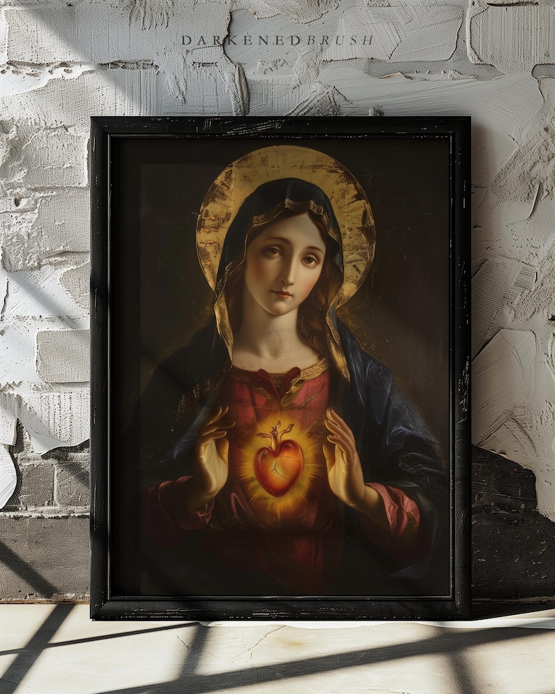 May include: A painting of the Virgin Mary with a golden halo, holding a glowing red heart in her hands. The painting is framed in a black frame.