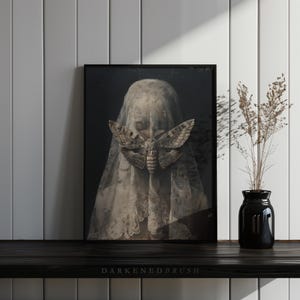 May include: A black and white photo of a person wearing a veil with a large moth covering their face. The moth is a death's-head hawkmoth, a species known for its skull-like markings on its thorax.