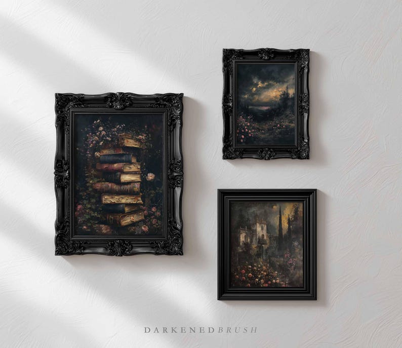 May include: Three framed art prints with ornate black frames. The artwork depicts a stack of books, a landscape with a cloudy sky, and a gothic building. The prints are mounted on a white wall.