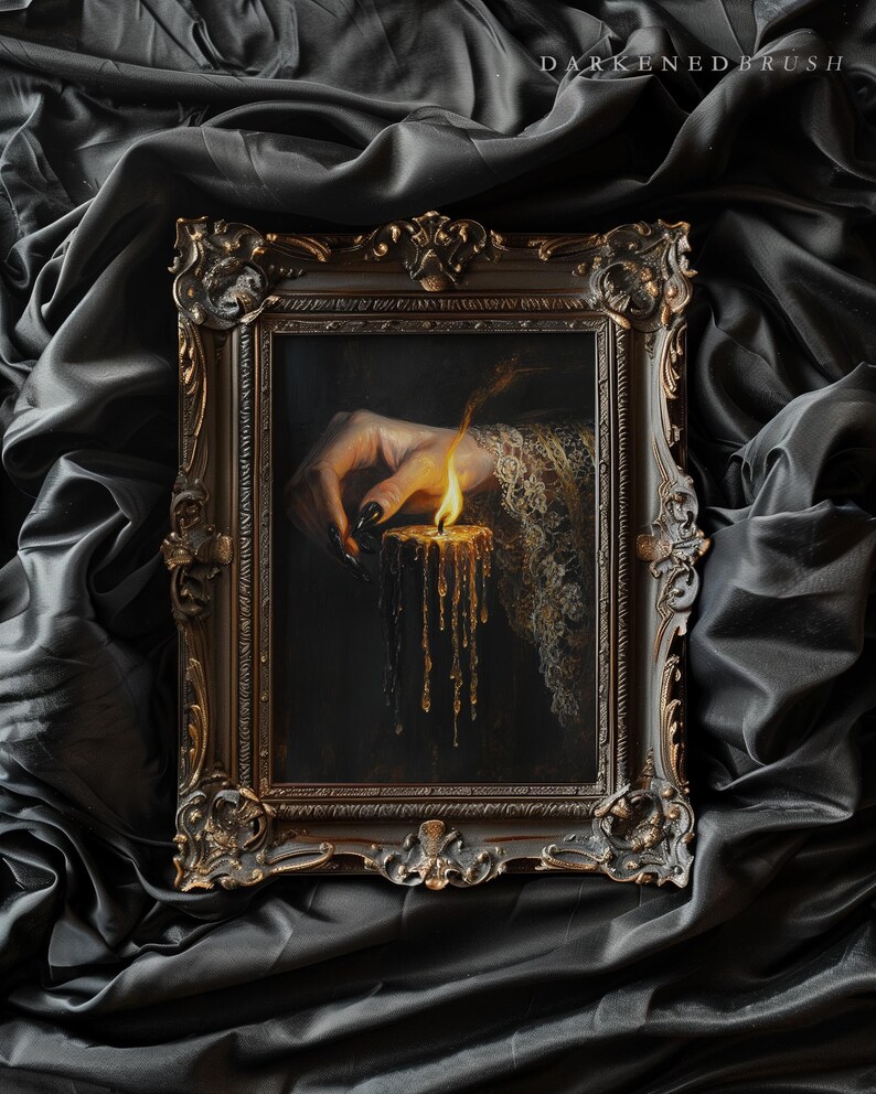 May include: Ornate framed artwork featuring a hand with long, black nails, lighting a candle. The candle's wax drips down, and the artwork is set against a dark, draped background. The frame has a detailed, antique design.